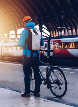 man with a bicycle at a train station